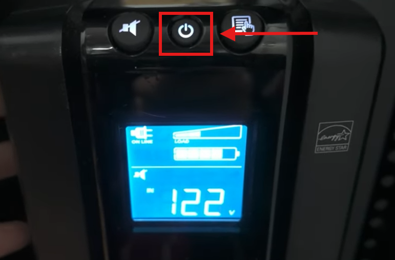 Front panel of a Back‑UPS Pro showing the power button highlighted. A red box and arrow indicate pressing and holding the power button to start the self‑test.